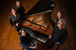 Gruppenfoto des Teams um einen Steinway Flügel positioniert. Von links nach rechts: Jörn Zehner, Petra König, Alexandra Prestle, Uwe König, Lilian Fischediek 